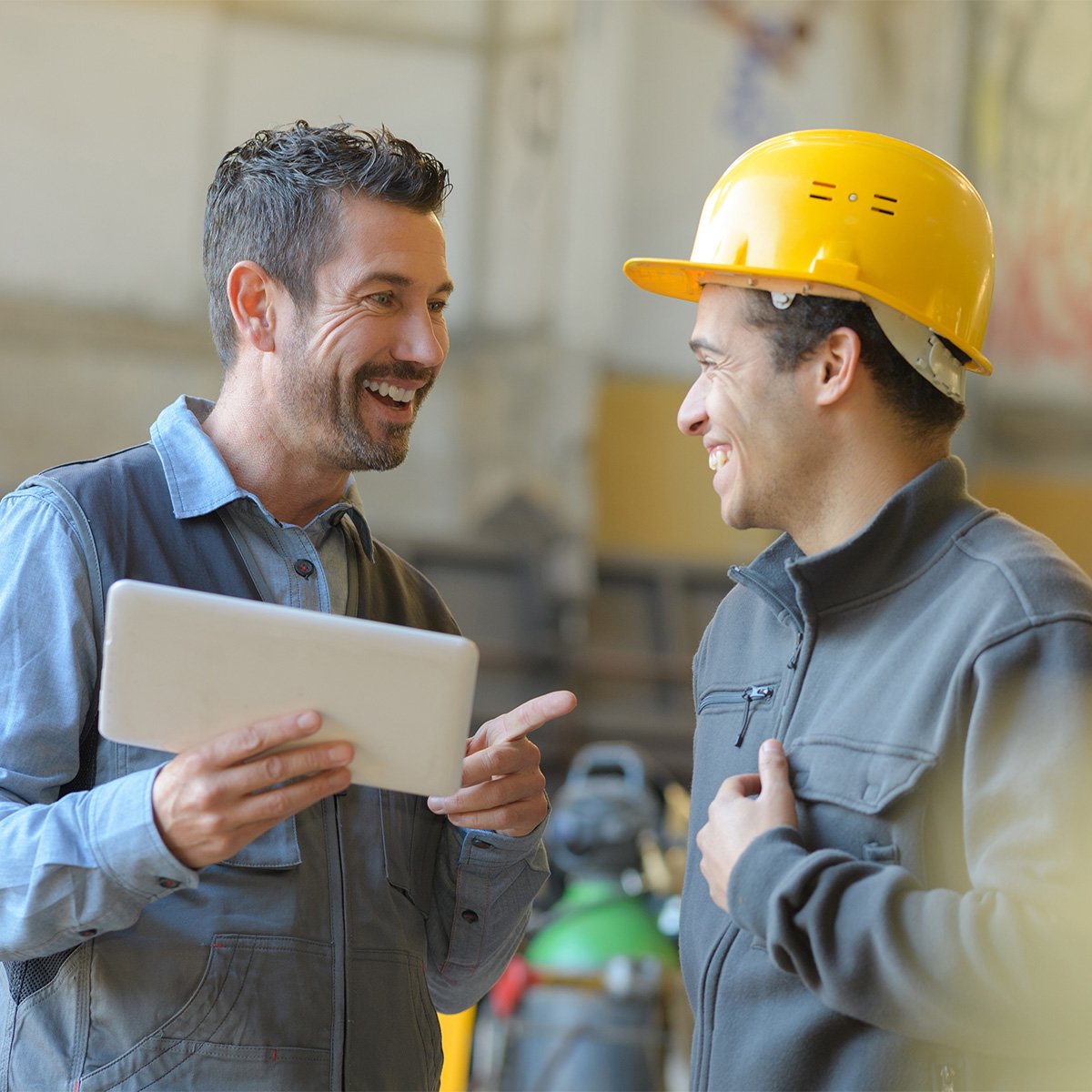 blue-collar-workers-interior-of-factory-with-mobile-tablet