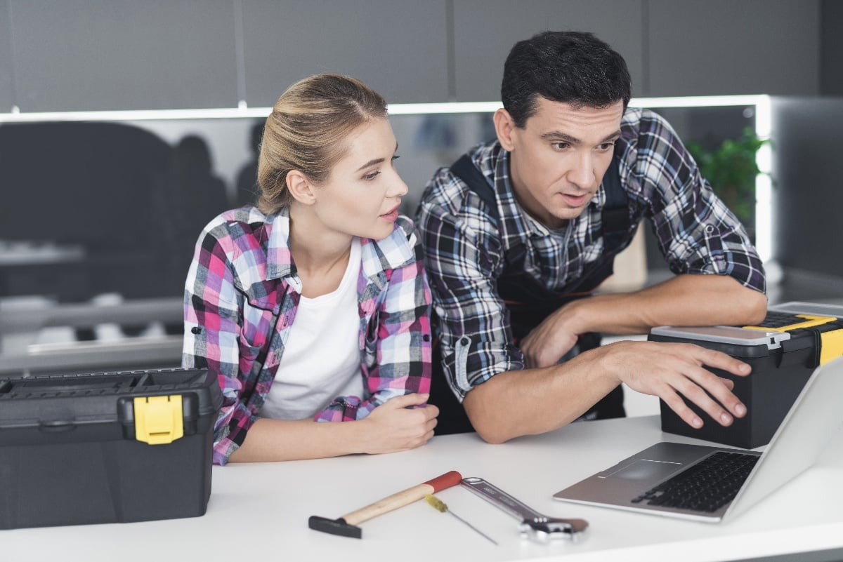 male-and-female-plumbers-in-kitchen-prepping-for-repair-1